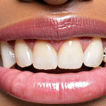 **

Healthy pink gums contrasted with dark, discolored gums. Close-up shot, focusing on the gum line and teeth. Illustrates the effects of smoking, melanin, and poor oral hygiene on gum color. Include a toothbrush in the scene for context. Japanese text overlay: "歯茎の色の変化、原因と対策" (Gum Color Changes: Causes and Solutions). Style: Clean, clinical, informative.

**